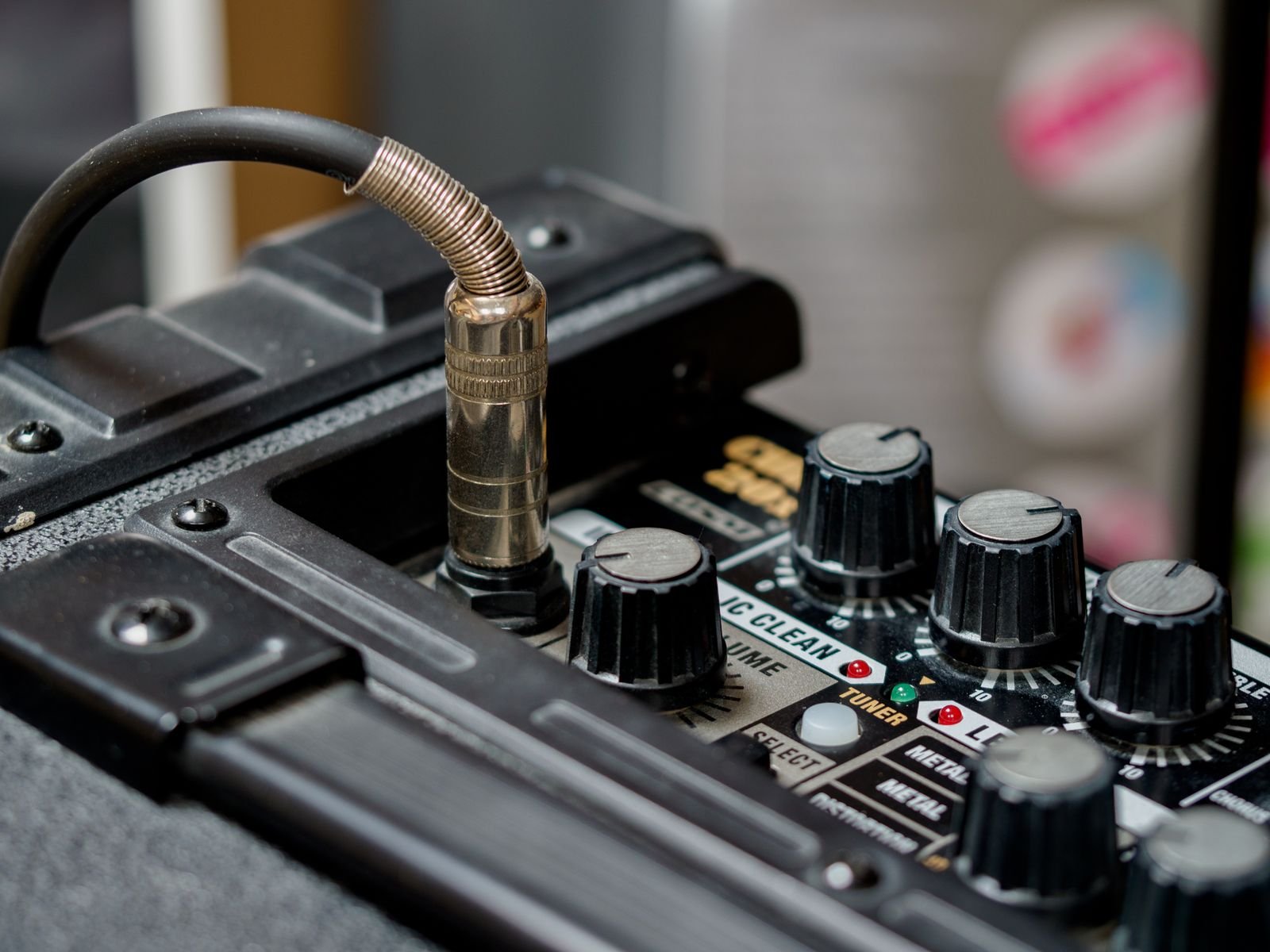 Close-up of an amplifier and multi-effects unit with knobs and a coiled cable