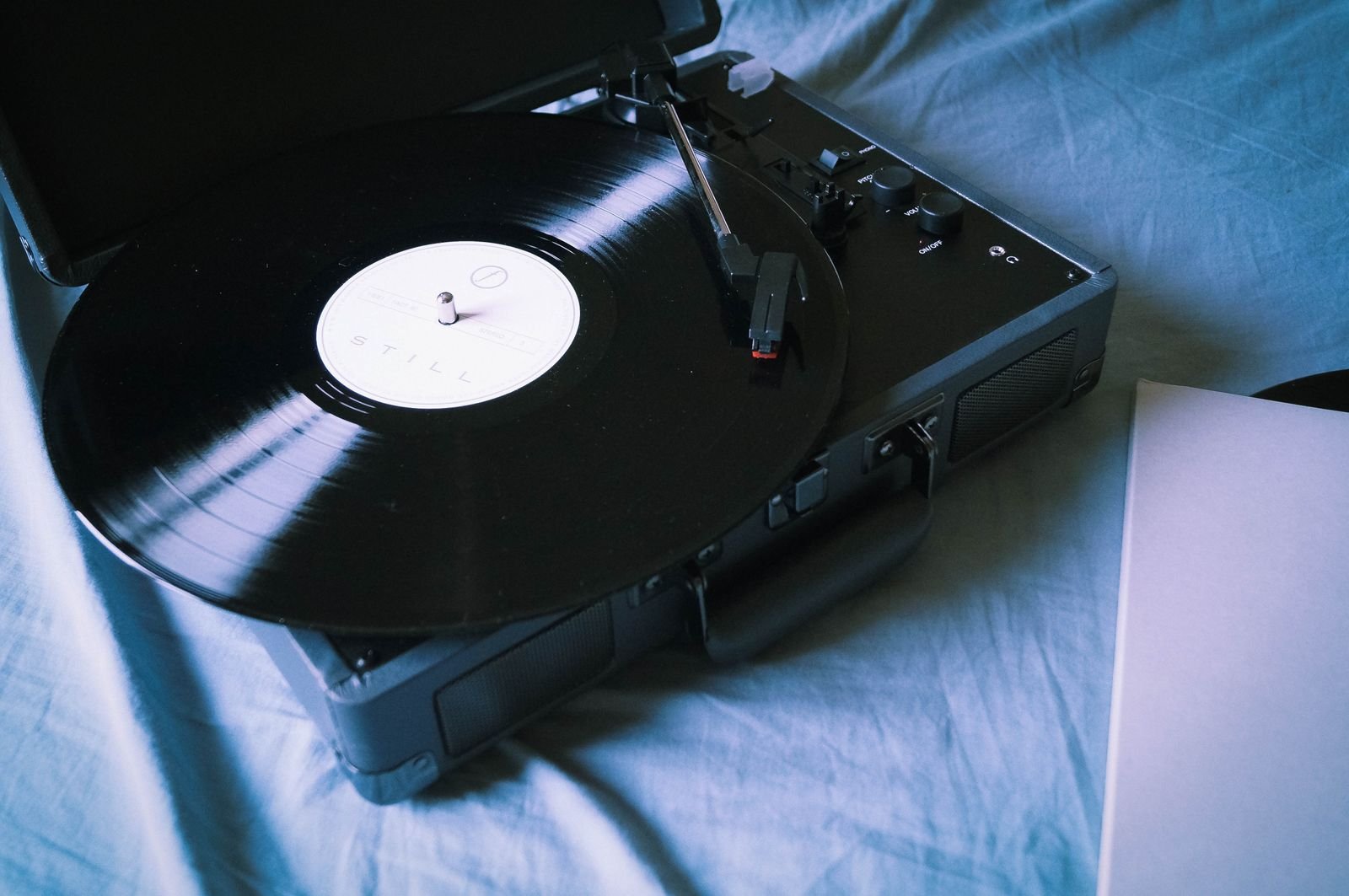 A black vinyl record on a turntable, lit warmly, evoking a 1994 grunge album